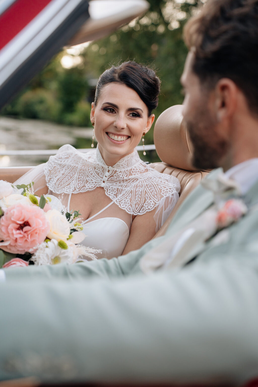 Portrait des mariés en voiture pour un mariage printanier
