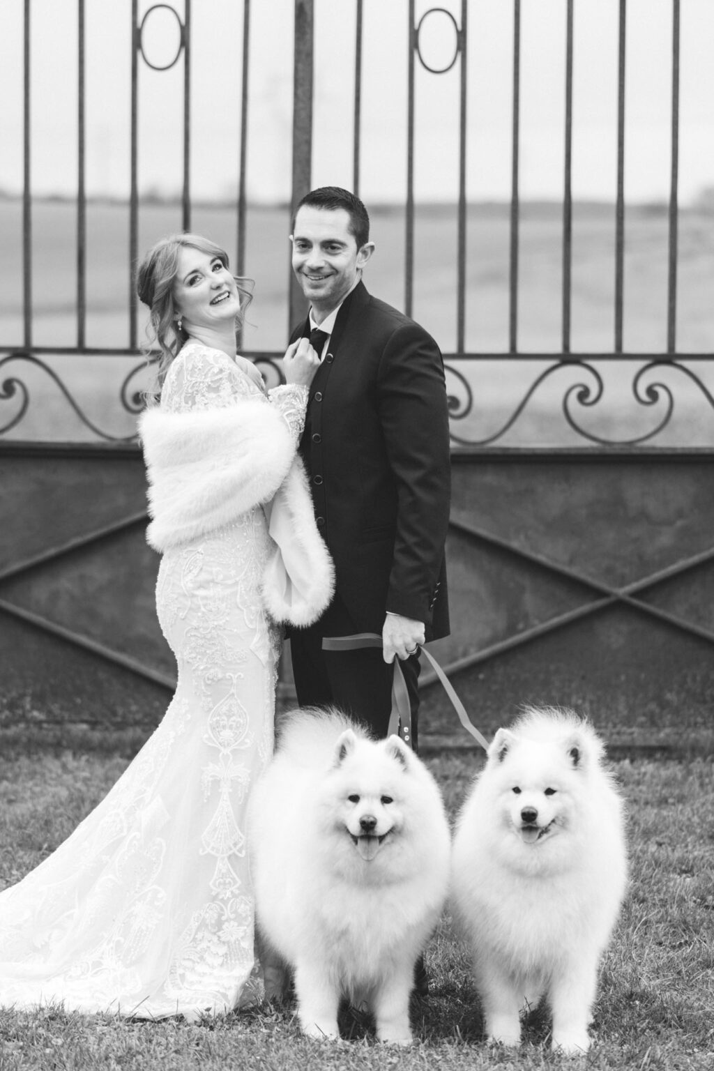 Portrait couple inspiration féerique devant un portail avec des chiens